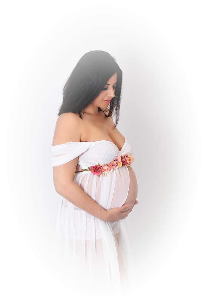 Mutter in weißem Kleid hält ihren Babybauch Fotograf PB Studios Achim
