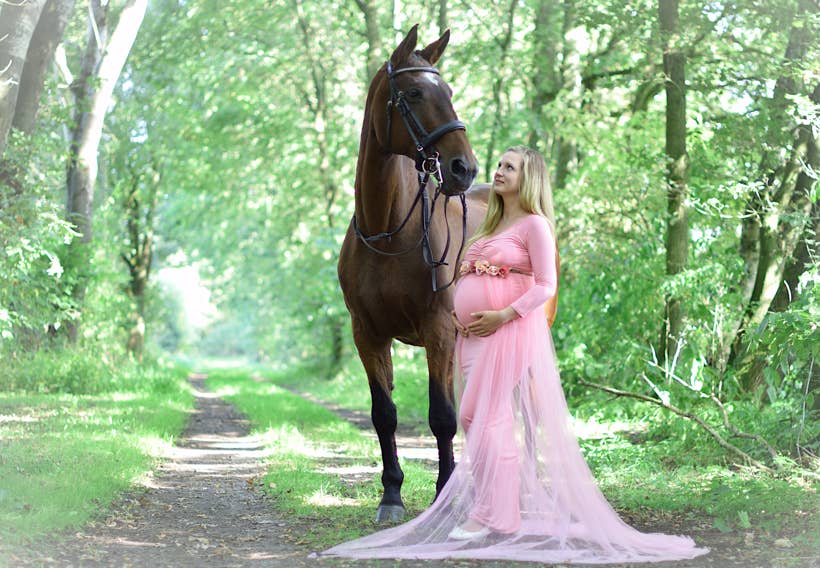 Mutter mit Babybauch im rosa Kleid neben einem Pferd im Wald Fotograf PB Studios aus Achim