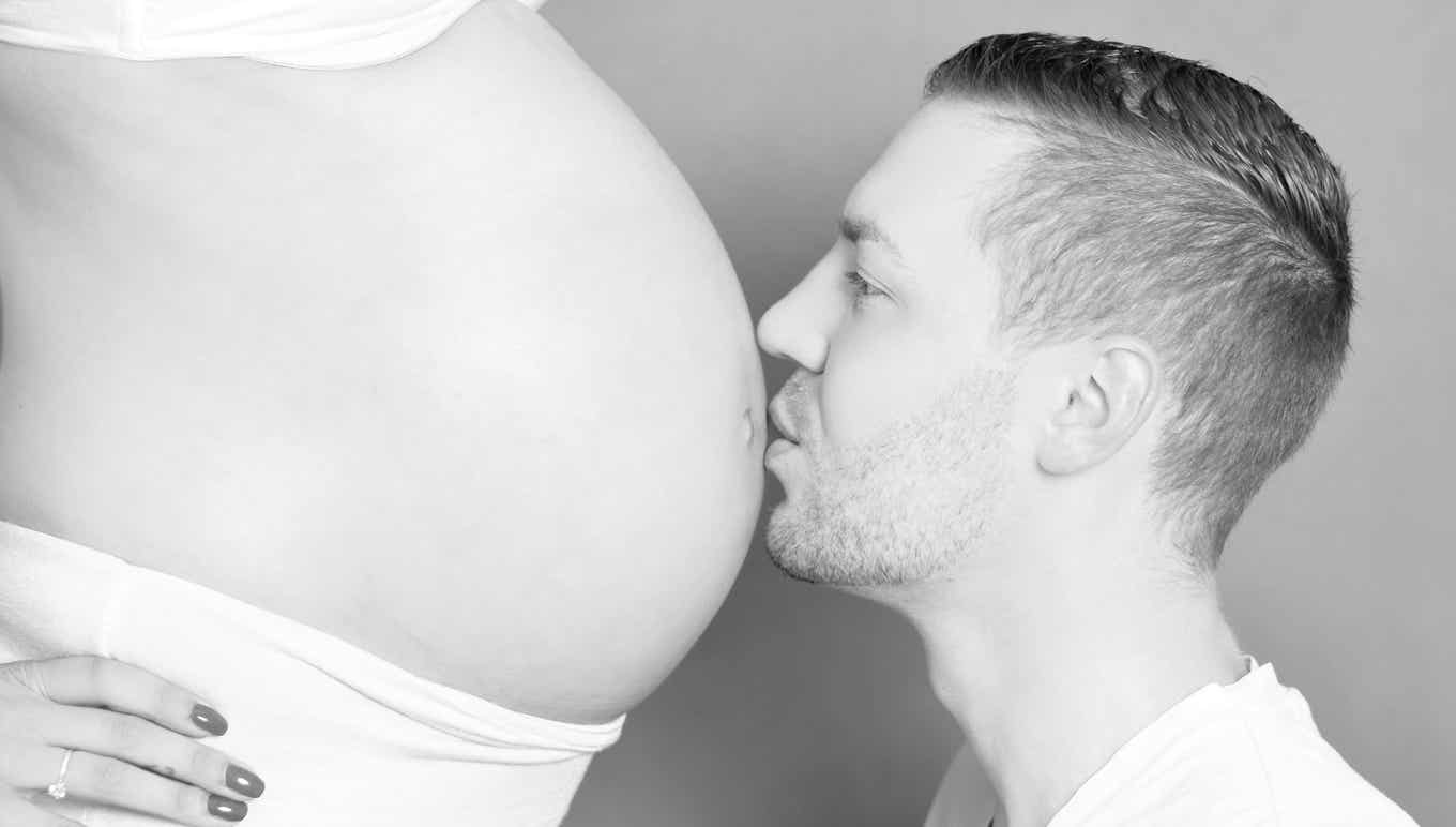 Vater küsst den Babybauch der Mutter schwarzweiß Fotograf PB Studios aus Achim